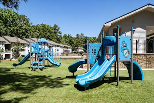 A playground with a blue slide and a climbing frame.