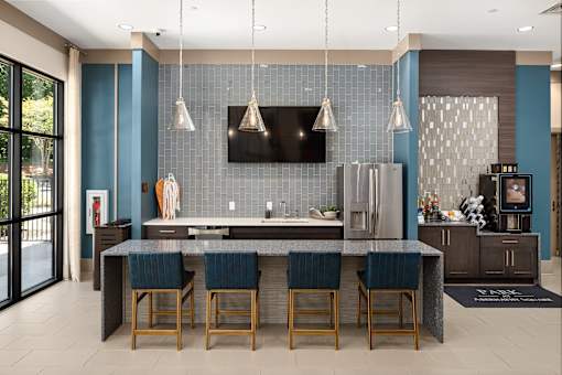 A modern kitchen with a dark blue backsplash and a central island.