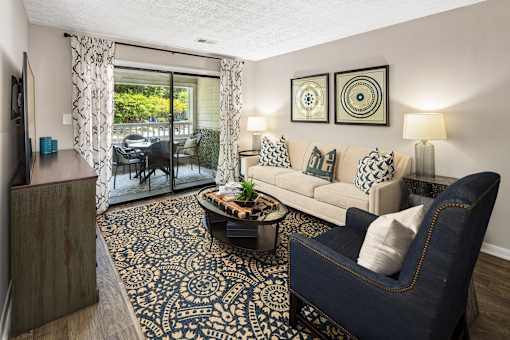 A living room with a blue chair and a patterned rug.