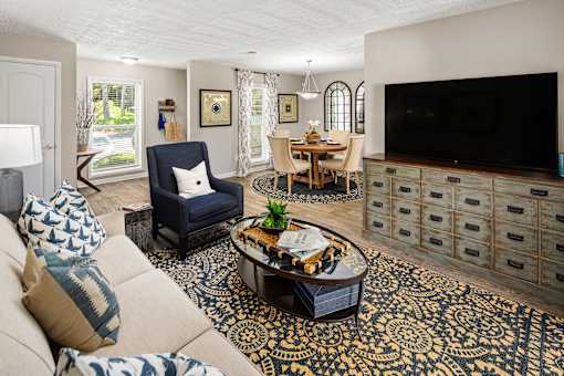 A living room with a blue chair and a patterned rug.