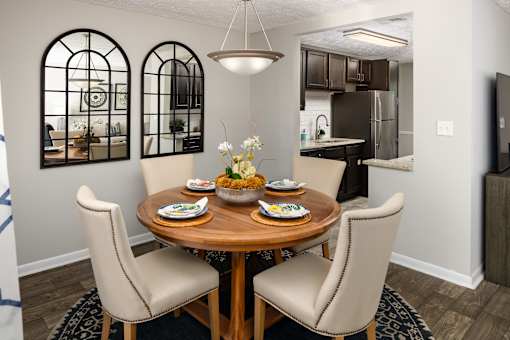 A dining room with a round wooden table and chairs.