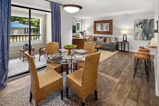 A dining room with a glass table surrounded by chairs.