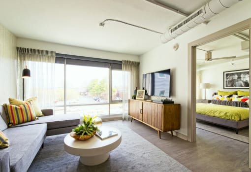 a living room with a couch and a coffee table    and a bedroom