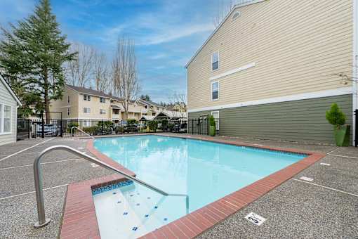 A small pool with a red border and a metal handrail.