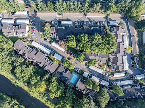 A bird's eye view of a residential area with houses, roads, and a river.