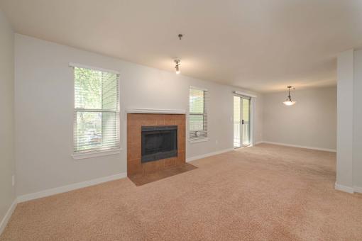 A living room with a fireplace and carpeting.