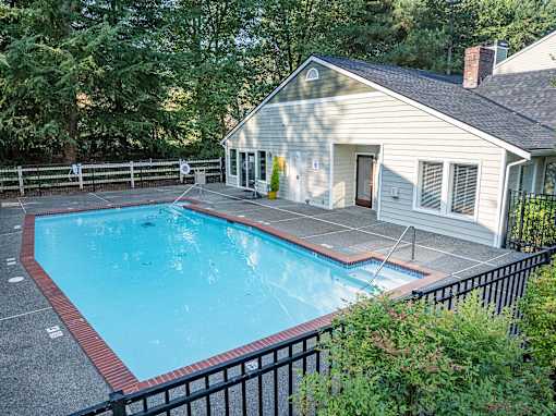 A small house with a pool in the backyard.
