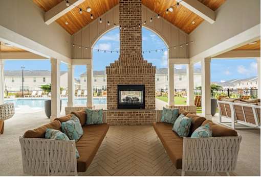 A modern living room with a fireplace and a view of the pool and buildings outside.