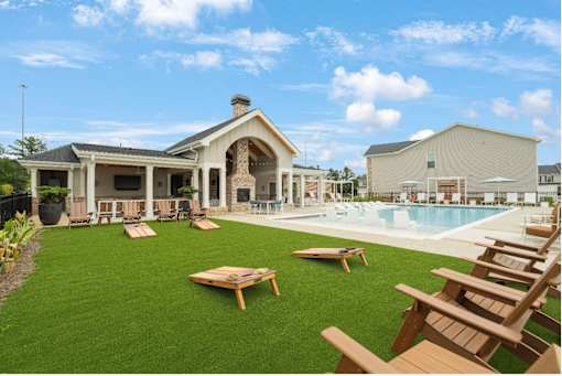 A house with a pool and lawn chairs.