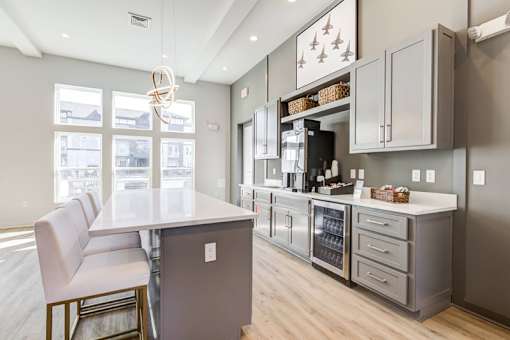 A kitchen with a white counter top and a white chair.