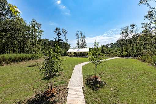 a path leading to a house in the middle of a field