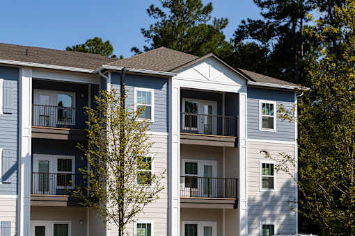 an apartment building with trees in the background