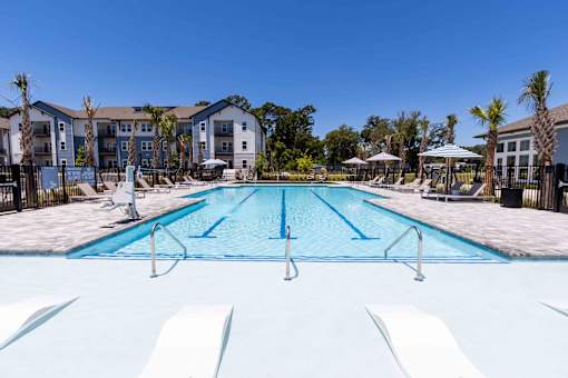 A large swimming pool in front of apartment buildings.