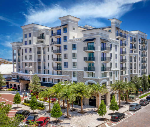 an aerial view of a large apartment building with a parking lot and palm trees in the foreground at Altis Grand Central, Tampa, FL