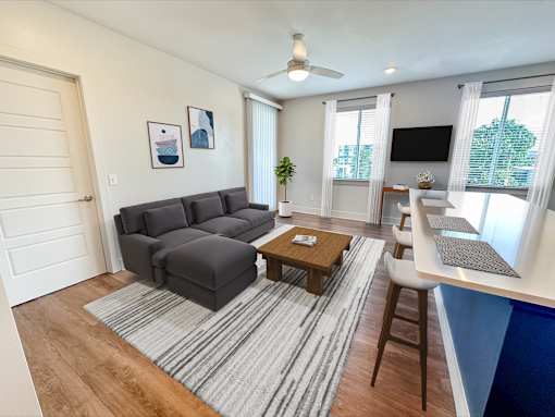 A living room with a grey sofa and a wooden coffee table.