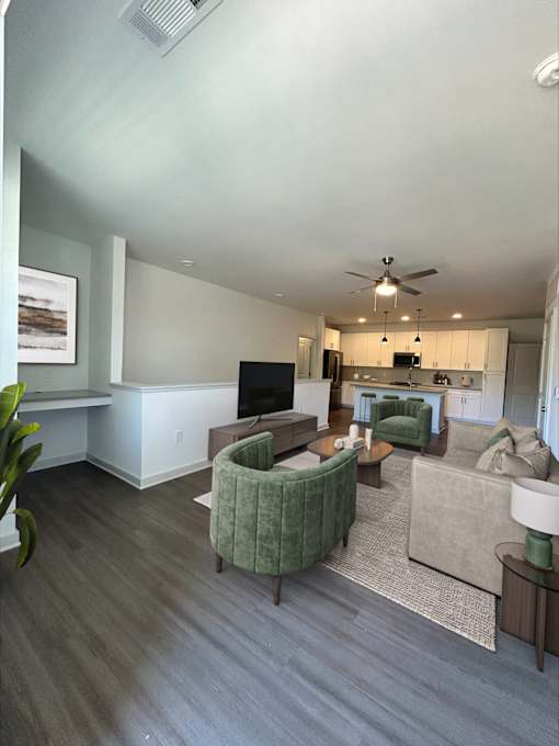 A living room with a green chair and a television.