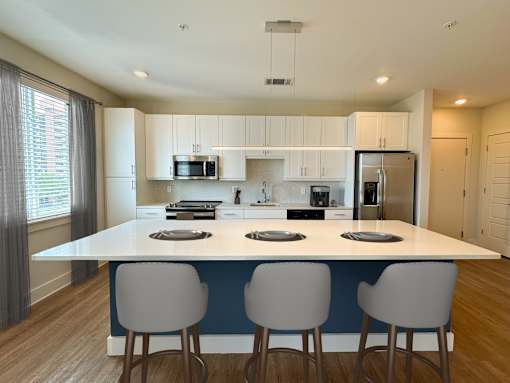A modern kitchen with a large island and bar stools.