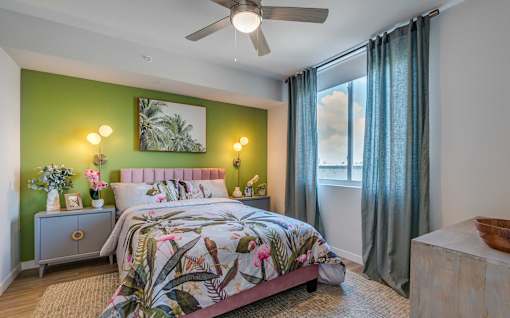 A bedroom with a bed, nightstand, and a painting on the wall.