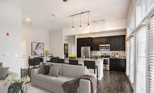A modern kitchen with dark wood cabinets and a white island.