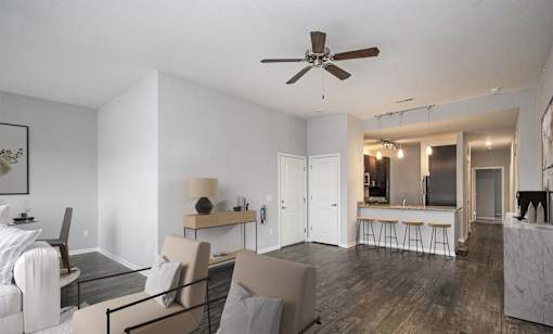 A modern living room with a dining area and kitchen in the background.