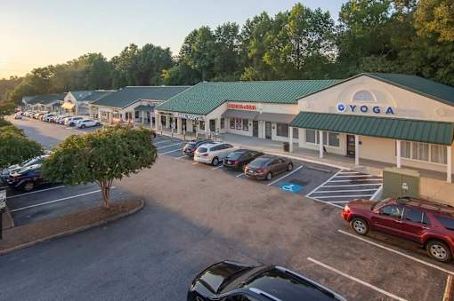 A parking lot with a yoga studio in the background.