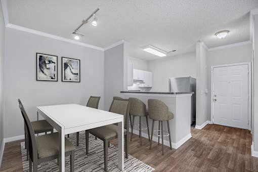 A kitchen with a dining table and chairs.
