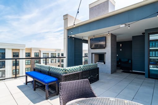 a rooftop patio with a fireplace and a blue table and chairs