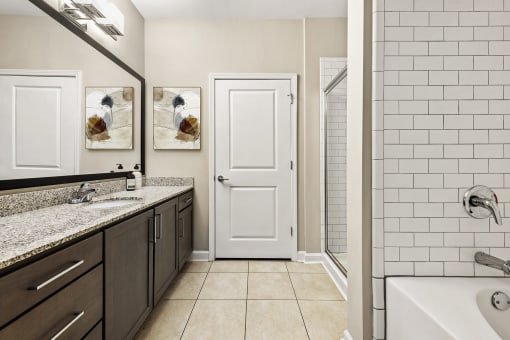 a bathroom with a sink and a shower and a white door