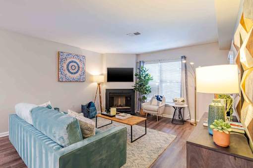 A living room with a blue couch and a fireplace.