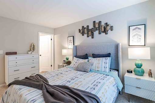 A bedroom with a large bed and a dresser.