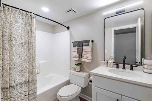 A bathroom with a white toilet, a white sink, and a shower curtain.