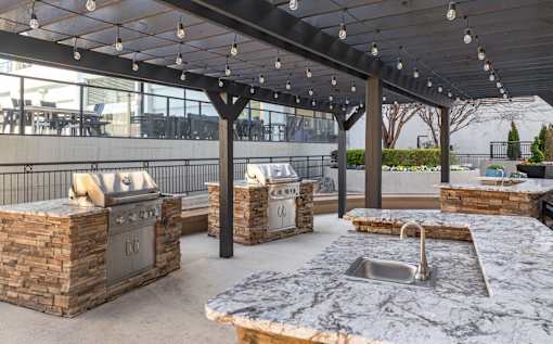 A patio with a stone counter and a sink.