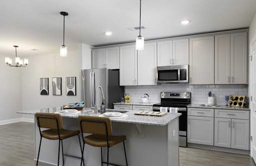 A modern kitchen with a white countertop and grey cabinets.