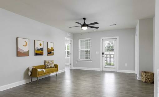 A room with a yellow bench and three framed pictures on the wall.
