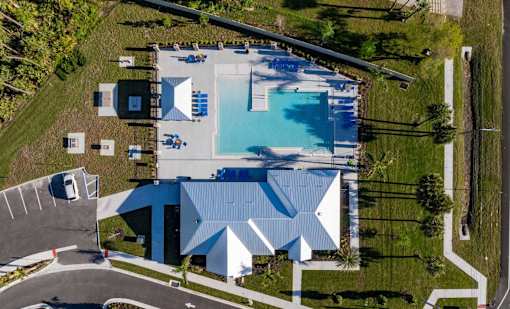 An aerial view of a swimming pool and a building with a blue roof.