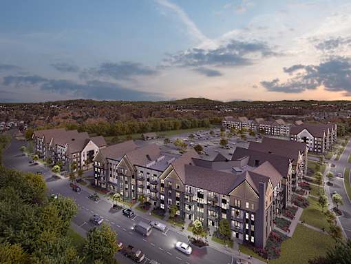 A large apartment complex with a parking lot in front.