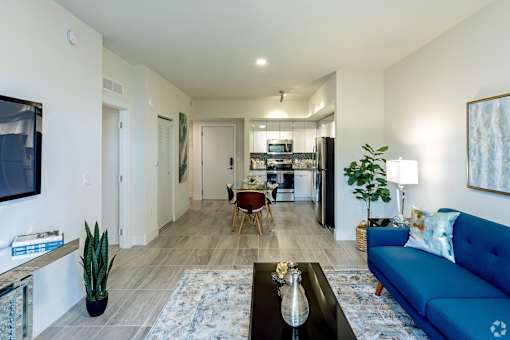 A living room with a blue couch and a coffee table at Saba Pompano Beach, Pompano Beach, 33062