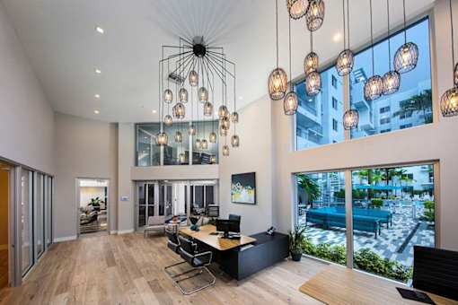A modern office with a large window overlooking a pool and buildings at Saba Pompano Beach, Pompano Beach, 33062