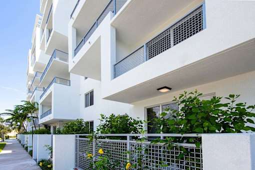 A white building with balconies and plants in front at Saba Pompano Beach, Pompano Beach, 33062