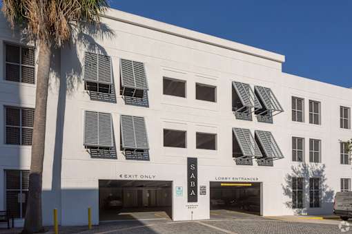 A white building with a palm tree in front of it at Saba Pompano Beach, Pompano Beach, 33062
