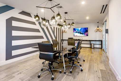 A conference room with a striped wall and a television mounted on the wall at Saba Pompano Beach, Pompano Beach, 33062