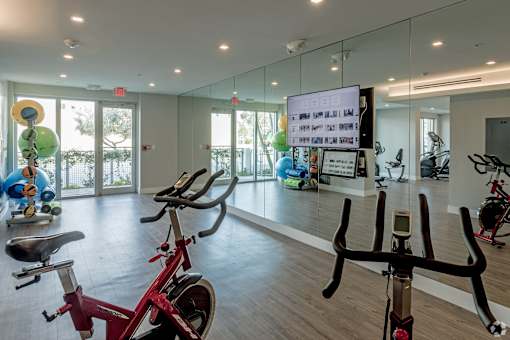 A gym with exercise bikes and a mirror at Saba Pompano Beach, Pompano Beach, 33062