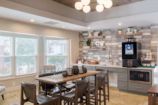 A kitchen with a dining table and chairs.