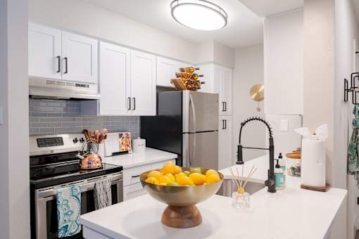 A kitchen with a bowl of lemons on the counter.