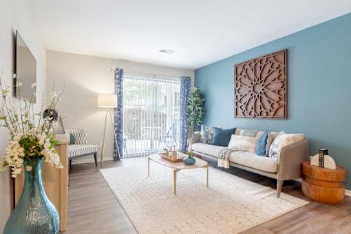 A living room with a blue vase and a white sofa.