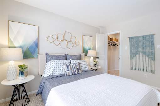 A bedroom with a large bed and a painting on the wall.