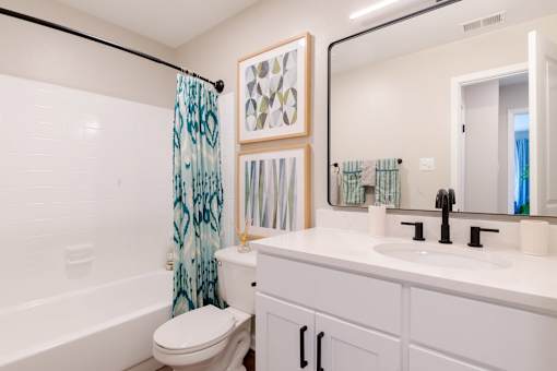 A white bathroom with a toilet, sink, and shower.