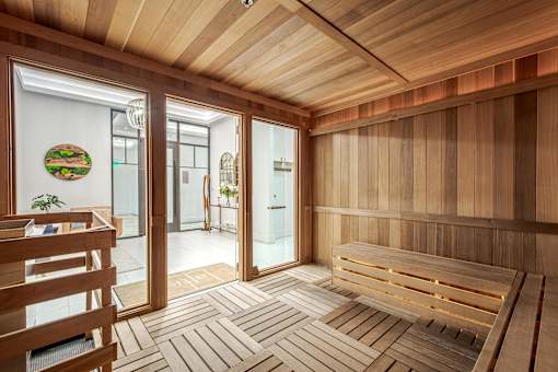 A wooden sauna room with a bench and a door.