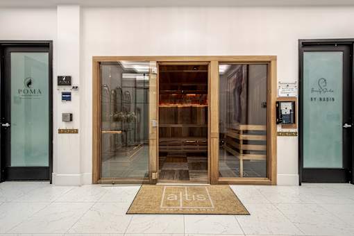 The entrance to a building with a glass door and a wooden door.