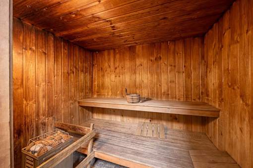 A wooden sauna with a bench and a table.